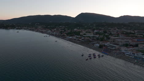 Drone-Shot-of-Laganas,-Zakynthos-Island,-Greece-After-Sunset,-Town-Buildings-and-Beach,-Aerial-View
