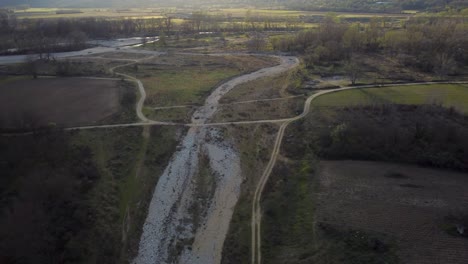 Aerial-view-of-valley-with-dried-up-river-at-golden-hour-in-winter