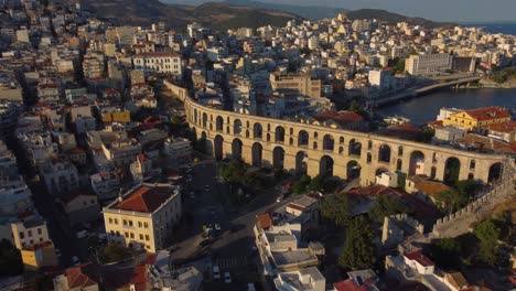 Slow-aerial-pan-of-ancient-Roman-aqueduct-in-Kavala,-Greece-at-sunset
