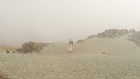 Attractive-woman-walk-through-foggy-desert-in-Teide-national-park