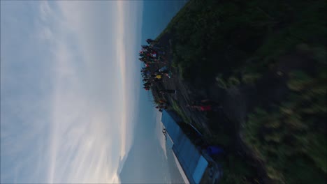 Drone-flying-around-crowd,-Mount-Batur-in-Bali,-vertical-shot,-beautiful-sunrise,-hiking-group,-sunflares-in-people-silhouettes,-epic-view-of-volcano-peak,-indonesia,-sun-rise-hike-on-mount-Batur