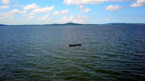 Aerial-View-Of-Wooden-Fishing-Boat-Amidst-Waterscape-Of-Lake-Victoria,-Kenya