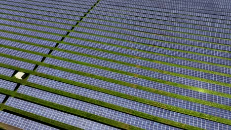 Granja-Solar-Fotovoltaica-Que-Genera-Energía-Limpia-Y-Ecológica,-Vista-Aérea,-Luz-Solar-Brillante,-Vuelo-Lento-De-Drones-Hacia-Atrás