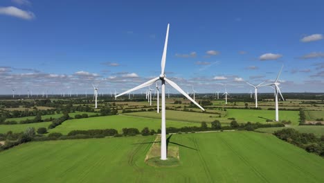 Wind-turbines-farming-wind-energy,-green-fields,-blue-sky,-countryside,-sunny,-green-sustainable-power,-renewable-power-source