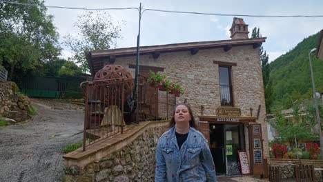 A-Woman-Wearing-Denim-Jacket-Walking-On-The-Mountain-Village-Of-Rasiglia,-Umbria-Hills,-Province-of-Perugia,-Italy