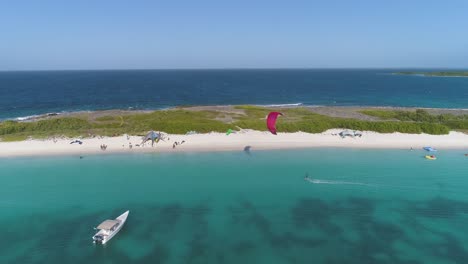 Kitesurfistas-Disfrutando-Del-Agua-Azul-Clara-En-La-Isla-Crasqui,-Los-Roques,-Aéreo