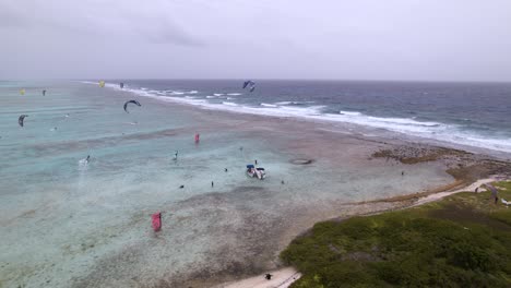 Kite-surfers-enjoying-the-clear-blue-water-of-the-east-barrier-of-Los-Roques,-aerial