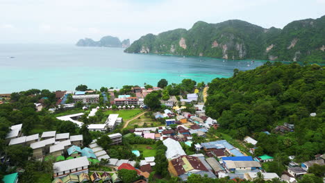 Aerial-dolly,-pan-left-above-hotel-lawn-overlooking-blue-water-of-koh-phi-phi-thailand