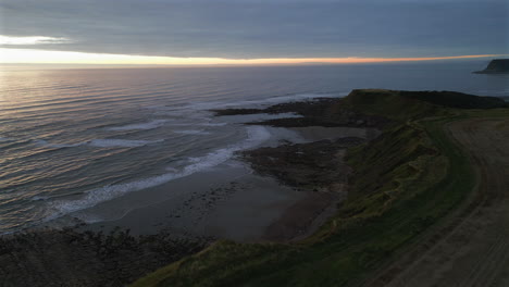 Establishing-Aerial-Drone-Shot-Over-Cleveland-Way-at-Sunrise-at-Low-Tide-in-Scarborough