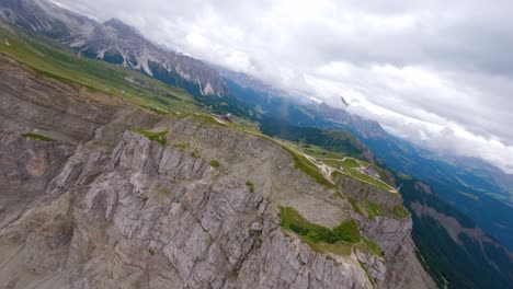 FPV-drone-flying-above-the-sharp-mountain-cliffs-of-Seceda,-Italy,-Dolomites-mountains-in-the-Alps