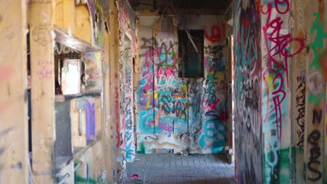 Four-Tourists-Walk-through-the-Abandoned-Graffiti-Covered-Fort-Chiniki-Gas-Station-in-Canmore-Alberta-Canada