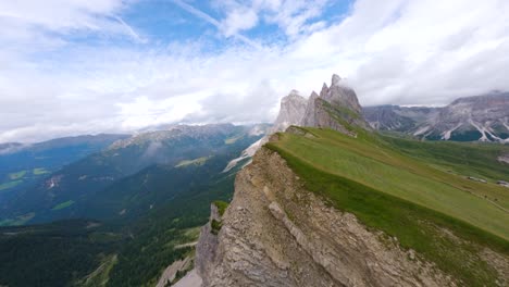 FPV-drone-flying-close-of-the-sharp-mountain-cliffs-of-Seceda,-Italy,-Dolomites-mountains-in-the-Alps
