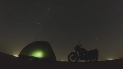 Timelapse-De-Estrellas-En-El-Cielo-Nocturno-Con-Tienda-De-Campaña-Y-Bicicleta-En-Primer-Plano-En-Un-Desierto-En-El-Lago-Sambhar-Jaipur-Rajasthan-India
