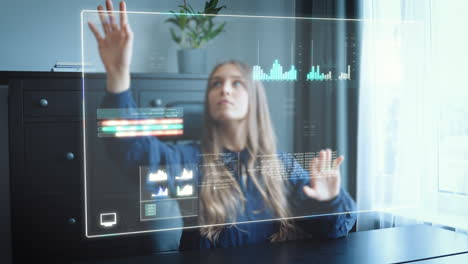 Business-woman-in-home-office-works-on-futuristic-HUD-hologram-screen-and-pushes-around-tables,-graphs-and-statistics-via-gesture-control