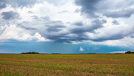 Cloudscape-and-rain-storm-as-a-combine-harvester-gathers-crops---time-lapse