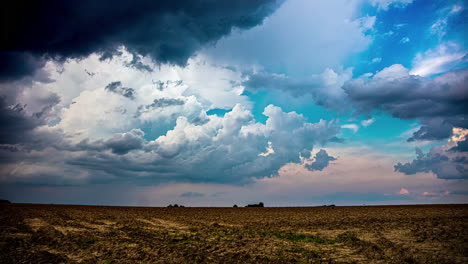 Dark-clouds-and-a-rainstorm-over-farmland-fields-in-the-countryside---time-lapse