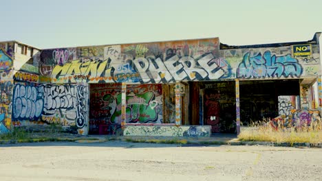 Panning-across-the-Fort-Chiniki-Abandoned-Graffiti-Street-Art-Painted-Gas-Station-and-Tourist-Destination-off-Highway-One-Near-Canmore-Alberta-Canada