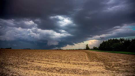 Storm-clouds-gather-over-a-freshly-harvested-farmland-field---dramatic-cloudscape-time-lapse