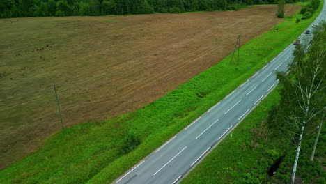 Aerial-Drone-Footage-Captures-Vehicles-on-a-Countryside-Highway-in-a-Low-Angle-Tracking-Follow-Dolly-Shot