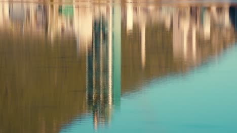 A-Reflection-in-the-Lake-water-of-the-Lafarge-Exshaw-Limestone-Cement-Plant-Industrial-Building-off-Trans-Canada-Highway-One-in-the-Canadian-Rocky-Mountains