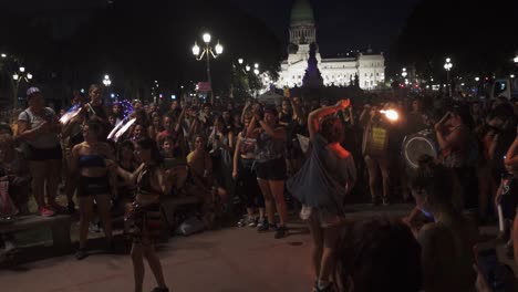 Fire-performers-dance-and-poi-swing-inside-circle-of-women-near-Congreso-de-la-Nacion-at-night