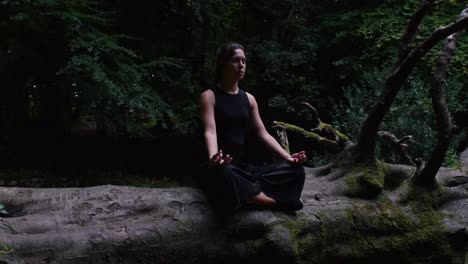 Ruhiger-Zen-Moment-Einer-Jungen-Frau,-Die-Auf-Einer-Grünen-Lichtung-Meditiert,-Zeitlupe