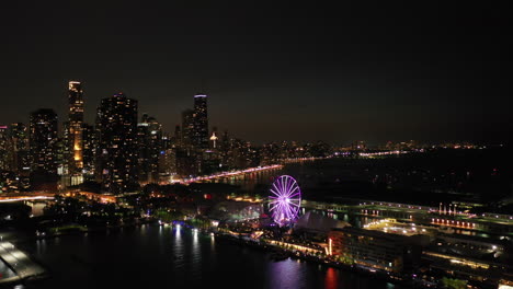 Aerial-view-circling-toward-the-night-lit-Centennial-Wheel-and-the-Navy-Pier-in-Chicago,-USA