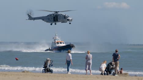 Spectators-at-Beach-Looking-at-Coast-Guard-Training-Exercise-with-Lifeboat-and-NH-90-Military-Helicopter-SLOMO