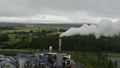 Factory-in-Norwegian-countryside-emits-harmful-greenhouse-gases,-aerial-arc