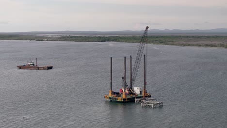 Refueling-sea-platforms-with-crane-for-cargo-ships-in-Manzanillo,-Dominican-Republic