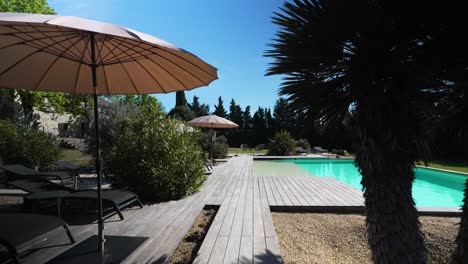 Slow-revealing-shot-of-a-private-pool-with-sun-loungers-within-a-villa-in-Nimes