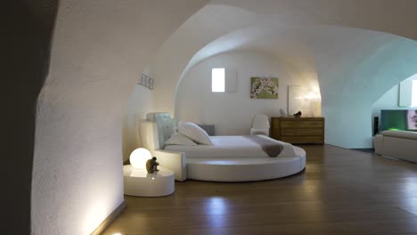 Slow-revealing-shot-of-a-open-plan-bedroom-and-living-room-with-beautiful-arches