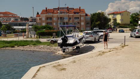 Vehicle-reversing-trailer-to-launch-speedboat-into-shallow-water-at-Marina-Medulin,-Croatia