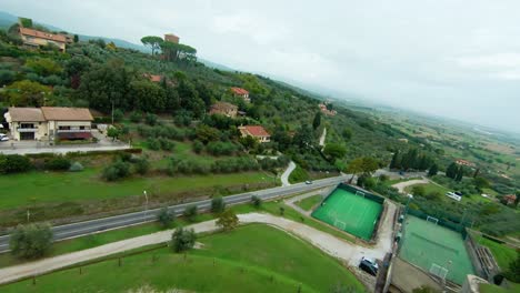 Drone-Sobrevolando-Pintorescas-Casas-Medievales-Y-Alrededores-Naturales-En-Lucignano,-Toscana-Italia