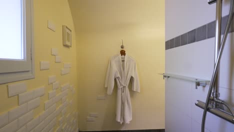 Tranquil-Bathroom-Retreat:-White-Bathrobe-and-Refreshing-Shower