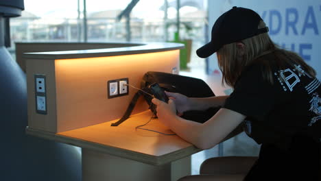 A-teenage-girl-using-a-phone-at-a-charging-station-at-an-airport