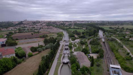 Aerial-revealing-shot-of-a-staged-canal-lock-in-the-countryside-of-Nimes