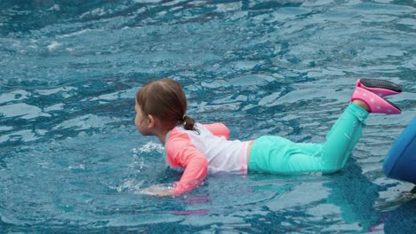 Lovely-Little-Girl-Playing-Lying-in-Water-Puddle-Pool-on-Her-Tummy-and-Splashing-with-Hands