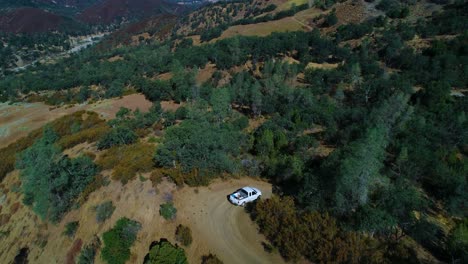 4k-drone-of-Truck-working-on-a-ranch-then-panning-up-to-mountain-views