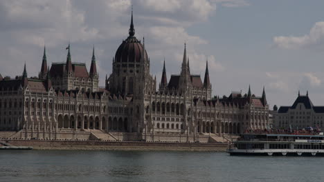 Hungarian-Parliament-Building-Pan-across-the-Danube-with-boat-on-a-hot-afternoon