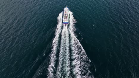 Aerial-follow-behind-glacier-tour-boat-on-Fjaerlandsfjorden-Fjord,-Norway