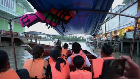 Local-and-foreign-tourists-taking-photos-and-videos-of-the-scenery-in-the-canals-of-Amphawa-Floating-Market-in-Samut-Songkhram,-Thailand