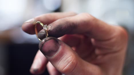 Nahaufnahme-Eines-Diamant-Eherings-Und-Schmutzige-Juwelierhände,-Die-Ihn-Halten