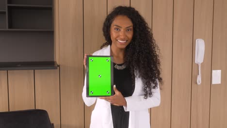 Schöne-Schwarze-Frau-Hält-Tablet-Mit-Grünem-Hintergrund-Und-Lächelt-Vertikal