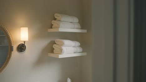 Neatly-folded-white-towels-on-bathroom-shelf