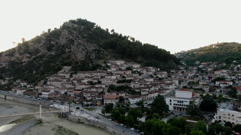 Berat,-the-city-of-a-thousand-windows:-aerial-view-traveling-out-of-the-famous-Albanian-houses-and-their-windows-and-the-Gorica-bridge-during-sunset