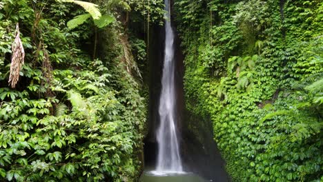 Static-Aerial-View-of-Leke-Leke-Waterfall-flowing-in-a-lush-green-tropical-jungle-paradise-of-Bali,-Indonesia