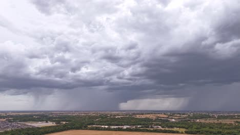 Overlooking-the-countryside,-rain-moving-across-sky-with-two-distinct-columns-of-precipitation-falling-onto-the-landscape