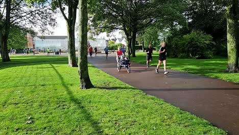 Slow-motion-group-of-people-jogging-in-charity-marathon-in-shaded-public-park