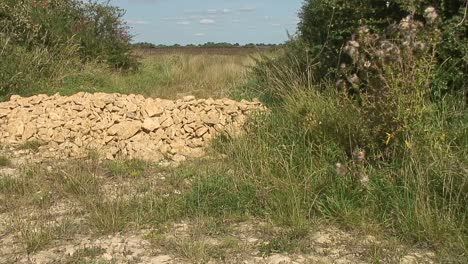 A-pile-of-sand-stones-blocking-a-gateway-to-a-field-used-to-prevent-vehicles-from-entering-the-field
